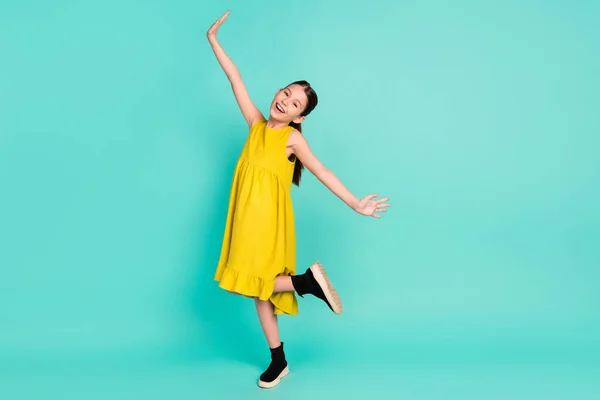 Pełny rozmiar zdjęcie optymistyczne ładne brązowe włosy dziewczyna taniec nosić żółtą sukienkę izolowane na jasnym ciemnym tle teal kolor — Zdjęcie stockowe