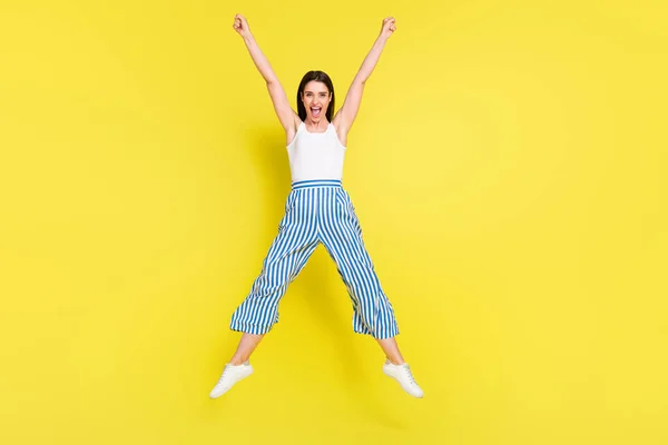 Full body foto di funky bruna giovane signora saltare urlare indossare pantaloni top sneakers isolato su sfondo di colore giallo — Foto Stock