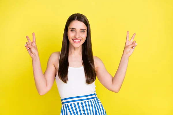 Portret van aantrekkelijke vrolijke meisje tonen dubbele v-teken met plezier geïsoleerd over helder gele kleur achtergrond — Stockfoto