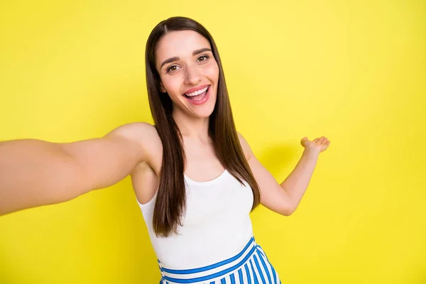 Selbstporträt eines attraktiven, fröhlichen Mädchens, das Kopierraum zeigt, um das neue Angebot auf lebendigem, gelbem Hintergrund zu demonstrieren — Stockfoto