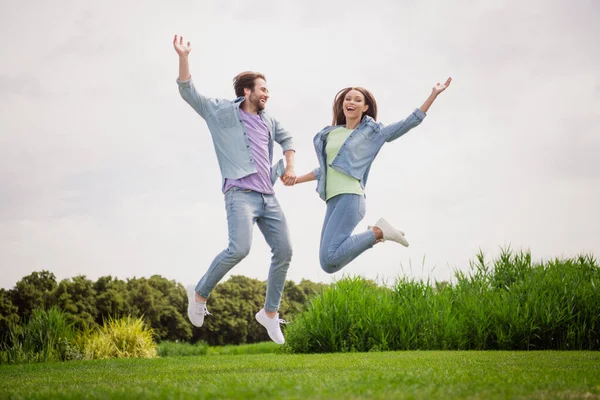 Full size photo of cheerful excited crazy funky funny married couple jumping around enjoying summer vacation — стоковое фото