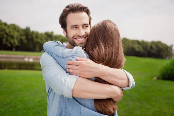 Photo of smiling handsome positive husband hug embrace wife best friends relaxing outdoors in park enjoy free time — Stock Photo, Image