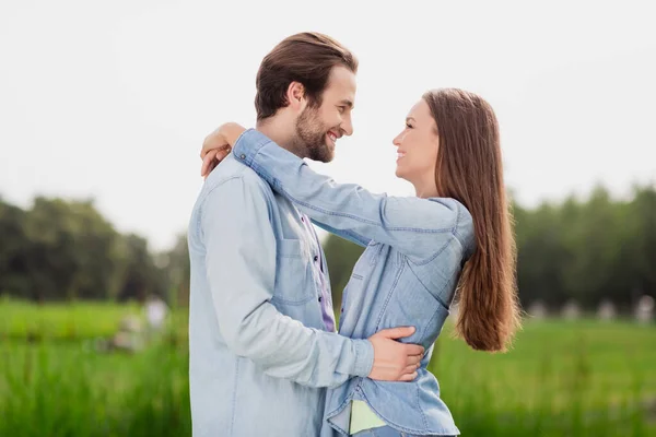 Profile side photo of two people lovely smiling couple hug embrace each other admire free time together outdoors in park — Stock Photo, Image