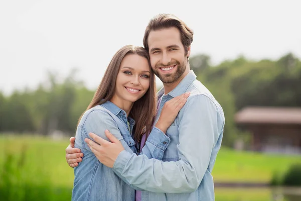 Фотопортрет молодая пара улыбается прогуливаясь в зеленом парке в синих джинсовых куртках летний вечер — стоковое фото