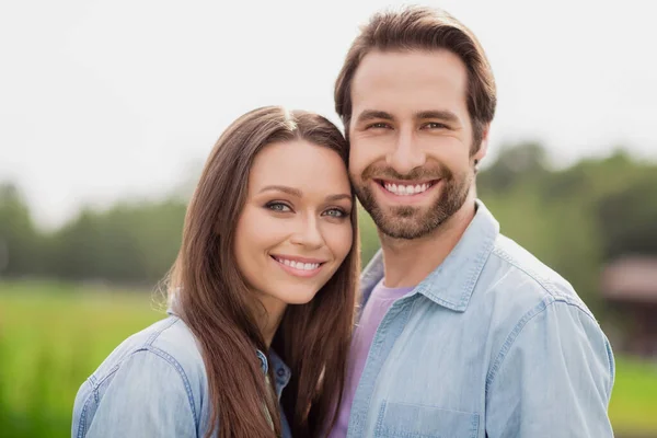 Foto portriat jovem casal sorrindo andando no parque da cidade verde vestindo jaquetas de ganga azul — Fotografia de Stock