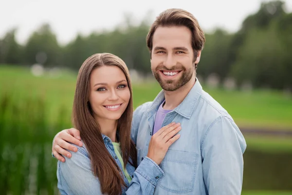 Foto portriat jovem casal sorrindo abraçando andando no parque da cidade verde usando jaquetas — Fotografia de Stock