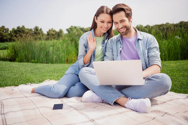 Photo of cheerful positive married couple relaxing outside hold laptop have online meeting with friends webcam say hello — Stock Photo, Image