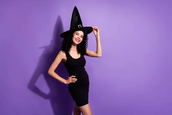 Retrato de menina alegre atraente vestindo pouco vestido preto boné cone posando isolado sobre violeta cor roxa fundo — Fotografia de Stock