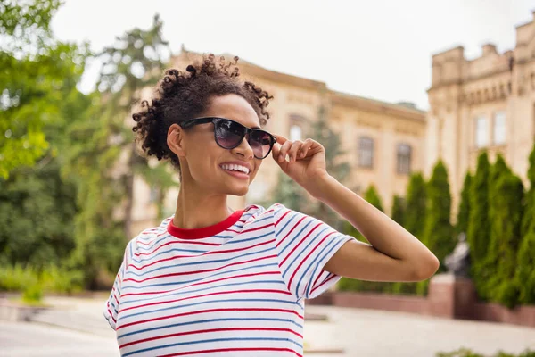 Zdjęcie portret kręcone dziewczyna noszenie sunglass paski t-shirt spacery po kampusie uczelni w lecie — Zdjęcie stockowe