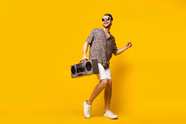 Full length photo of charming pretty young guy wear leopard outfit ciemne okulary gospodarstwa boom box odizolowany żółty kolor tło — Zdjęcie stockowe