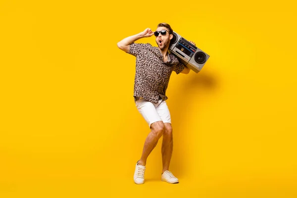 Foto de comprimento total de legal cavalheiro animado vestido impressão camisa braço óculos escuros dançando boombox isolado cor amarela fundo — Fotografia de Stock
