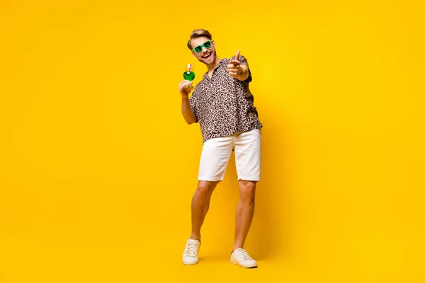 Lunghezza completa foto di attraente carino signore vestito stampa camicia bicchieri bere cocktail indicando isolato colore giallo sfondo — Foto Stock