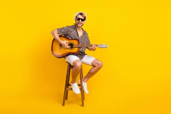 Photo of handsome cute young guy wear leopard outfit dark eyewear cap smoking playing guitar isolated yellow color background — Stock Photo, Image