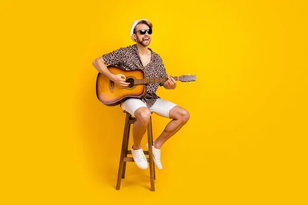 Foto de divertido caballero funky vestido camisa gafas oscuras tocando la guitarra cantando fumar aislado color amarillo fondo —  Fotos de Stock