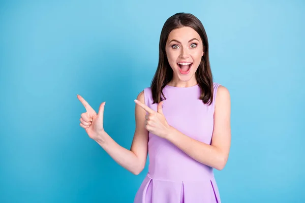 Foto van gelukkige charmante verrast meisje wijzen vingers copyspace winkelen geïsoleerd op glans blauwe kleur achtergrond — Stockfoto