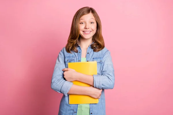 Foto Porträt Mädchen lächelnd halten Werbebuch in der Schule isoliert pastellrosa Hintergrund — Stockfoto