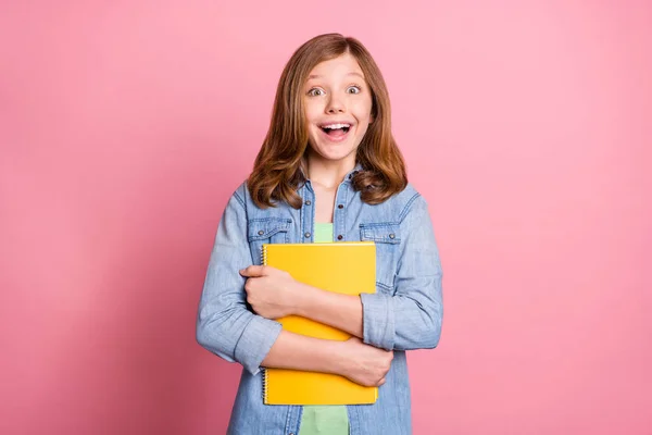 Foto de menina animada feliz sorriso positivo abraço abraçar caderno dever de casa isolado sobre fundo cor pastel — Fotografia de Stock