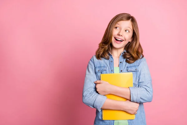 Foto portrét dívka usmívá vedení copybook hledá copyspace izolované pastel růžová barva pozadí — Stock fotografie