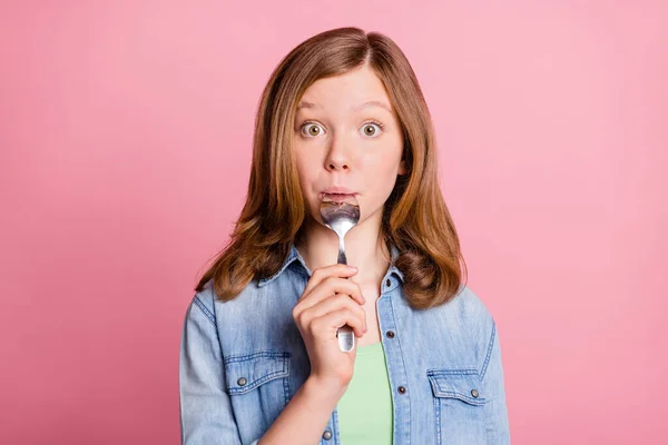 Foto retrato menina olhando fome lambendo colher isolado pastel cor-de-rosa fundo — Fotografia de Stock