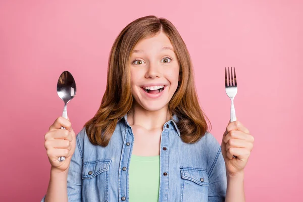 Foto retrato menina sorrindo mantendo garfo colher antes do jantar isolado pastel cor de rosa fundo — Fotografia de Stock