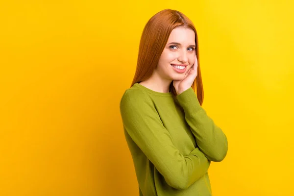 Foto retrato mulher de cabelos vermelhos em camisola verde sorrindo tocando bochecha isolado vívido cor amarela fundo copyspace — Fotografia de Stock