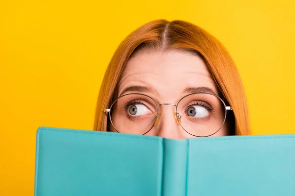 Foto de divertido peinado rojo joven dama leer libro mirada espacio vacío desgaste gafas aisladas sobre fondo de color amarillo —  Fotos de Stock