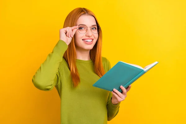 Foto retrato mujer pelirroja en gafas libro de lectura preparándose para la prueba aislado color amarillo vivo fondo —  Fotos de Stock