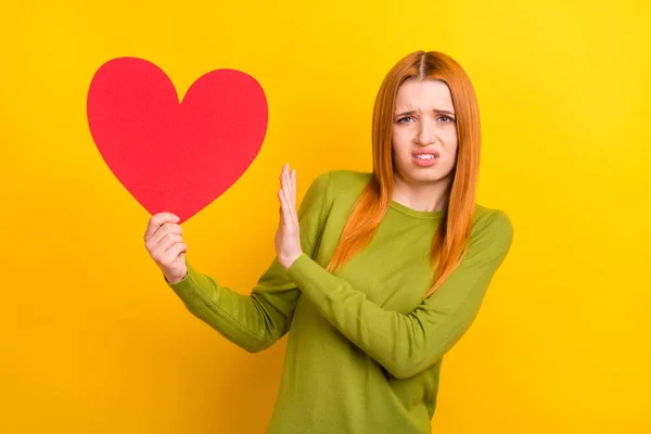 Foto retrato vermelho cabelo mulher mantendo coração recusando rejeitar isolado vívido cor amarela fundo — Fotografia de Stock