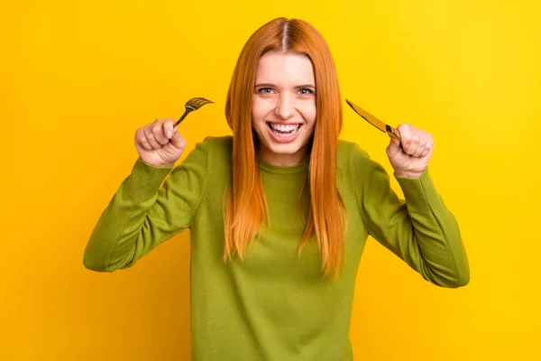 Foto de engraçado gengibre penteado jovem senhora quer comer desgaste jumper verde isolado no fundo de cor amarela — Fotografia de Stock