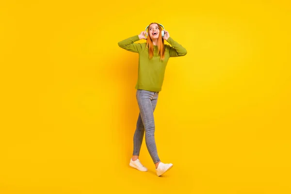 Comprimento total tamanho do corpo foto andando em fones de ouvido menina em roupa casual isolado vibrante cor amarela fundo — Fotografia de Stock