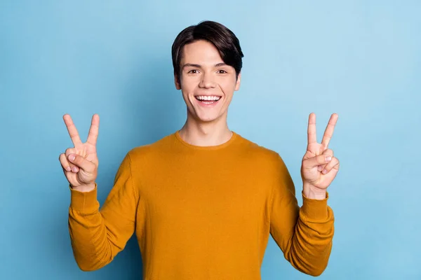 Fénykép a fiatal srác boldog pozitív mosoly mutatják béke hűvös v-jel üdvözlet elszigetelt kék szín háttér — Stock Fotó