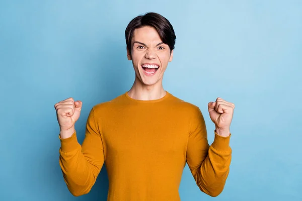 Foto av ung kille glad positiv leende glädje vinna vinnare seger mästare fläkt tur isolerad över blå färg bakgrund — Stockfoto