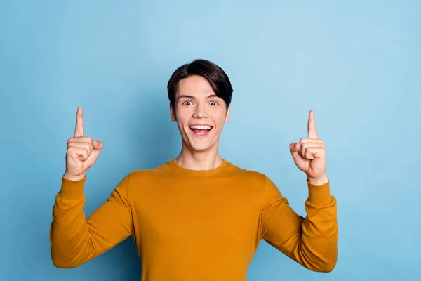 Foto av ung kille glad positivt leende indikerar fingrar upp direkt sätt annonser besluta isolerad över blå färg bakgrund — Stockfoto