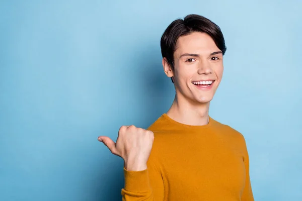 Profil sida foto av ung kille glad positiv leende indikerar tumme tomt utrymme annons råda beslut isolerad över blå färg bakgrund — Stockfoto