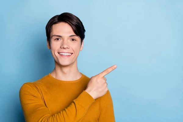 Foto von jungen Kerl glücklich positives Lächeln Zeigefinger leeren Raum Werbung Promo isoliert über blauen Farbhintergrund — Stockfoto