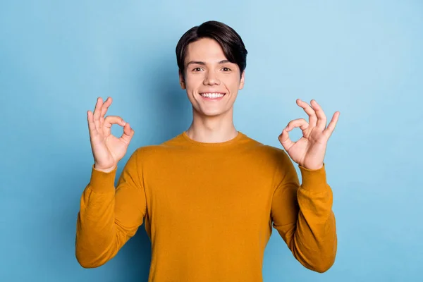 Foto di positivo ragazzo affidabile sorriso dentato mostrare due segno okey indossare camicia arancione isolato sfondo di colore blu — Foto Stock