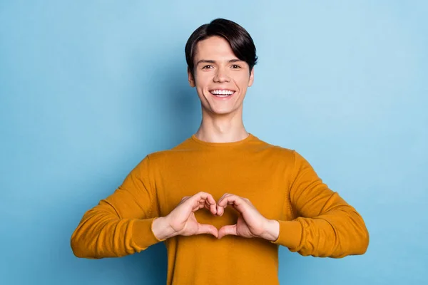 Foto de funky brunet millennial cara mostrar coração usar camisola marrom isolado no fundo de cor azul — Fotografia de Stock