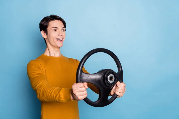 Profil fotografie vzrušený vtipný chlap držet volant vypadat prázdný prostor oblečení oranžová košile izolované modré barvy pozadí — Stock fotografie