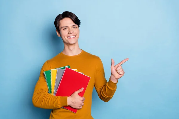 大学生手持抄本的照片直接手指空空荡荡的空间穿着橙色衬衫孤立的蓝色背景 — 图库照片