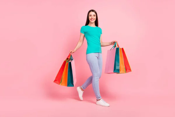 Perfil em tamanho completo foto lateral da jovem mulher feliz sorriso positivo ir segurar sacos de compras isolados sobre fundo cor pastel — Fotografia de Stock