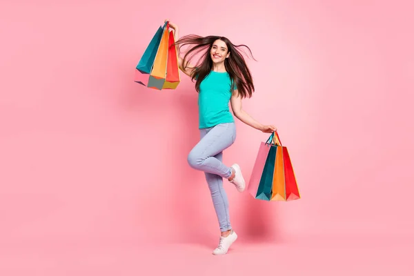 Full storlek profil sida foto av ung kvinna glad positiv leende hålla shoppingpåsar svart fredag isolerad över pastell färg bakgrund — Stockfoto