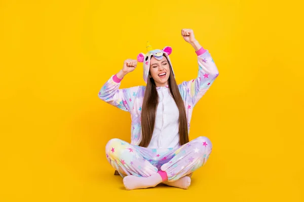 Portrait of attractive cheerful dreamy girl sitting having fun wearing cozy kingurumi isolated over bright yellow color background — Stock Photo, Image