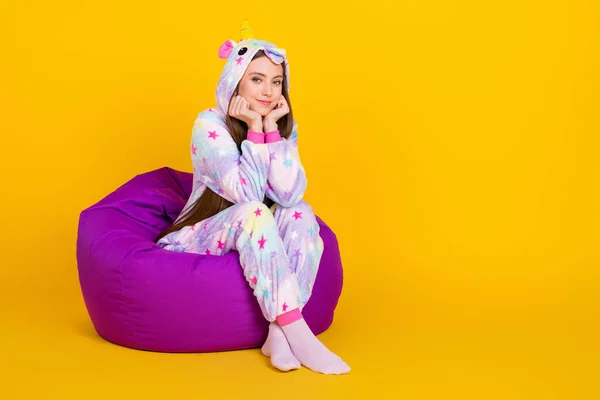 Longitud completa tamaño del cuerpo foto niña infantil con pijama sentado en beanbag aislado de color amarillo brillante fondo —  Fotos de Stock