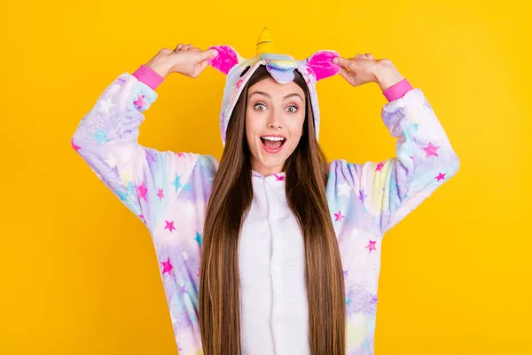 Foto retrato fêmea adolescente engraçado pijama mantendo ouvidos rindo feliz isolado vibrante amarelo fundo — Fotografia de Stock