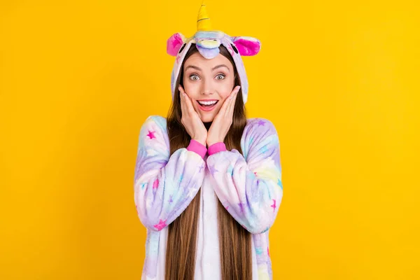 Foto retrato femenino adolescente divertido pijama sorprendido tocando mejillas aislado vibrante amarillo fondo —  Fotos de Stock