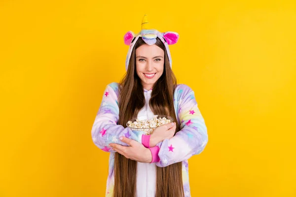 Photo portrait female teenager funny pajama keeping glass bowl pop corn watching movie isolated vibrant yellow background — Stock Photo, Image