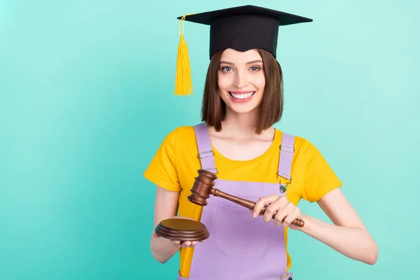 Foto de joven feliz encantadora mujer cogida de la mano juez martillo graduado aislado sobre fondo de color verde azulado —  Fotos de Stock