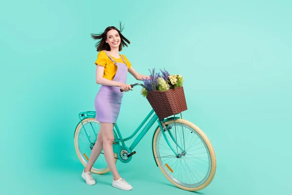 Pełne ciało zdjęcie wesołej młodej szczęśliwej pani wiatr cios włosy jazdy trzymać rower odizolowany na pastelowym ciemnym tle — Zdjęcie stockowe
