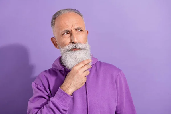 Retrato del atractivo hombre de pelo gris desconcertado que piensa demasiado en el espacio de copia aislado sobre el fondo violeta púrpura — Foto de Stock