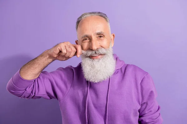 Porträtt av attraktiva preparerade glada gråhårig man vidröra fastställande mustasch isolerad över lila violett färg bakgrund — Stockfoto